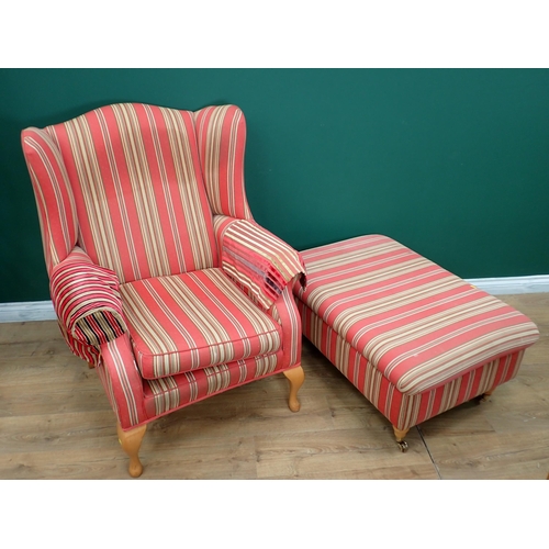 702 - An upholstered wingback Armchair with cabriole supports and a Footstool with matching upholstery