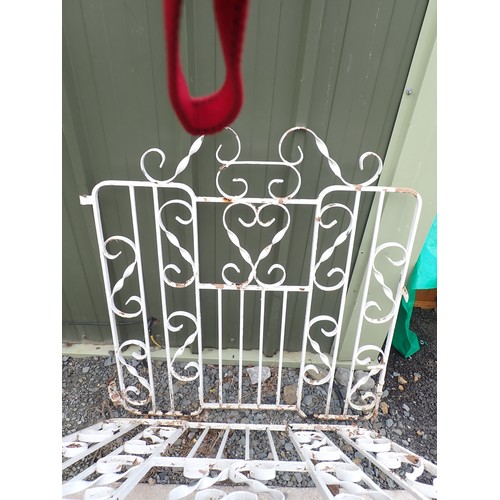 557 - A pair of white painted metal Garden Gates with twisted scrollwork design, 6ft 10in W approx