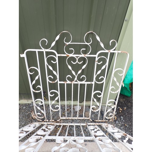 557 - A pair of white painted metal Garden Gates with twisted scrollwork design, 6ft 10in W approx