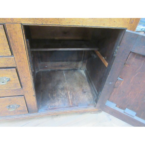 643 - An 18th Century oak and mahogany crossbanded enclosed Dresser Base fitted three frieze drawers above... 