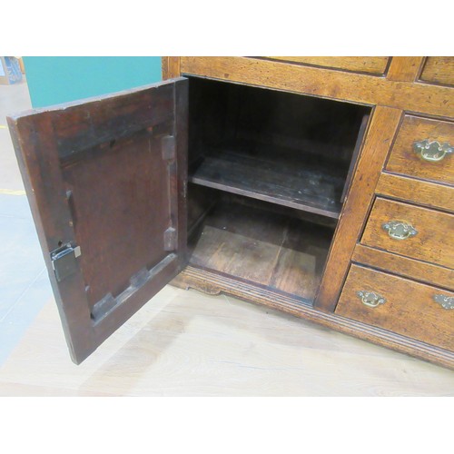 643 - An 18th Century oak and mahogany crossbanded enclosed Dresser Base fitted three frieze drawers above... 