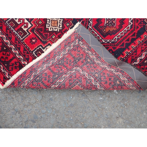 2 - A bordered Rug with six medallions on a red ground, 6ft 2in x 3ft 4in, a Saddle Bag and a small Rug