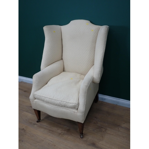 377 - An Edwardian wingback Armchair mounted on square cut tapering supports and casters 4ft H x 2ft 8in W