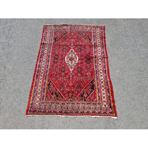 4 - An Iranian bordered Rug with stylised floral designs on a red ground, 10ft 4in x 6ft 9in