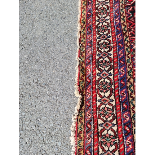 4 - An Iranian bordered Rug with stylised floral designs on a red ground, 10ft 4in x 6ft 9in