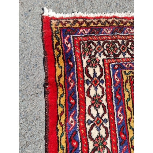 4 - An Iranian bordered Rug with stylised floral designs on a red ground, 10ft 4in x 6ft 9in