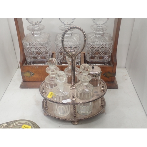 488 - An oak Tantalus with three Decanters, plated Cruet Set, Dressing Mirror, brass Clock Face and an old... 