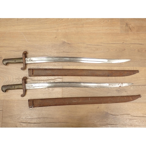 1457 - Two French brass handled Bayonets in metal scabbards