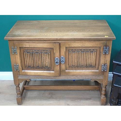 597 - An oak linenfold two door Cupboard and a Nest of three occasional tables