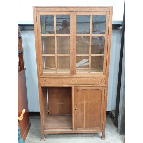 792 - An Arts and Crafts oak Cabinet with pair of glazed panelled doors above an inlaid frieze drawer with... 