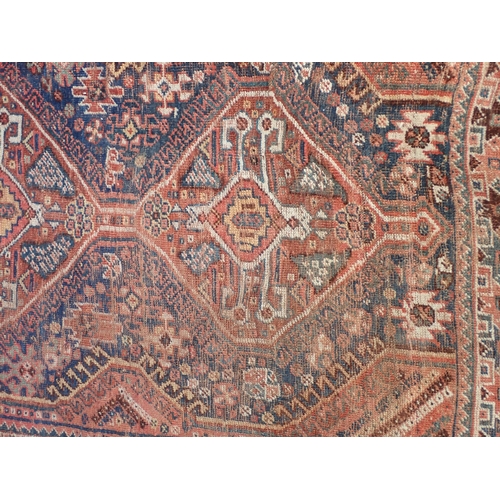 824 - A Persian woollen red ground Rug with blue medallions and two small Mats