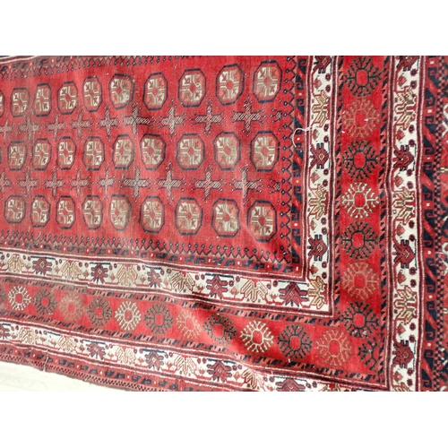 826 - A Persian woollen red ground Rug with three rows of medallions within multiple borders 6ft 6in L x 5... 