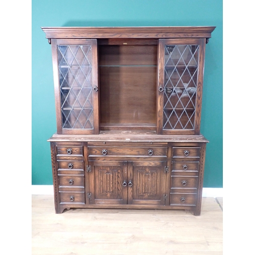 681 - A reproduction stained oak Bookcase, with pair of hinged glazed compartments, sliding to reveal a hi... 