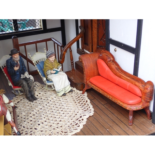 768 - A scratch built model of a timber framed black and white house, the roof made with areas of slating ... 