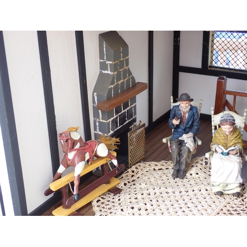 768 - A scratch built model of a timber framed black and white house, the roof made with areas of slating ... 