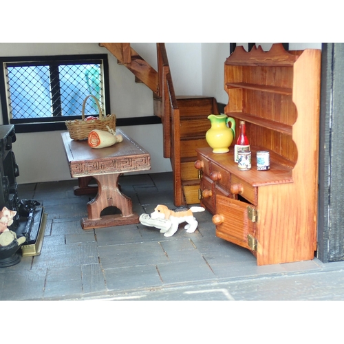 768 - A scratch built model of a timber framed black and white house, the roof made with areas of slating ... 