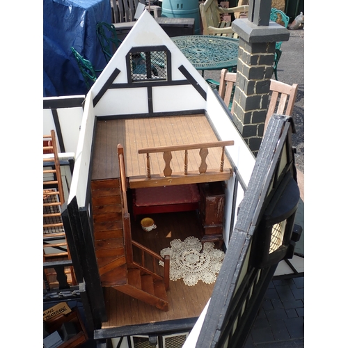 768 - A scratch built model of a timber framed black and white house, the roof made with areas of slating ... 