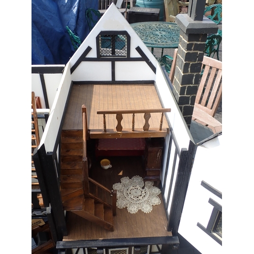 768 - A scratch built model of a timber framed black and white house, the roof made with areas of slating ... 