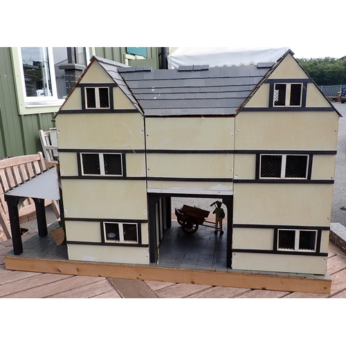 768 - A scratch built model of a timber framed black and white house, the roof made with areas of slating ... 