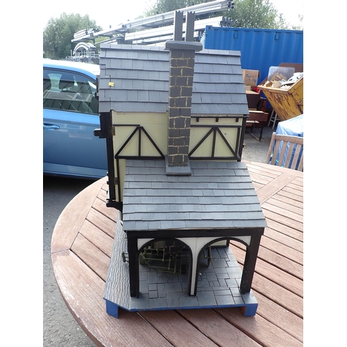 768 - A scratch built model of a timber framed black and white house, the roof made with areas of slating ... 