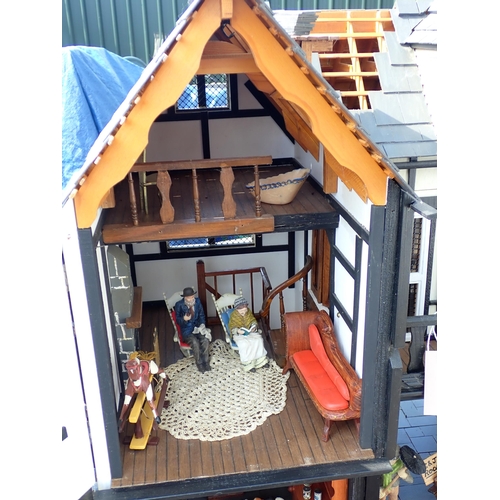 768 - A scratch built model of a timber framed black and white house, the roof made with areas of slating ... 