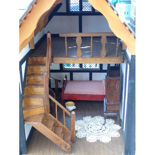 768 - A scratch built model of a timber framed black and white house, the roof made with areas of slating ... 