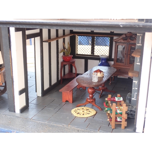 768 - A scratch built model of a timber framed black and white house, the roof made with areas of slating ... 