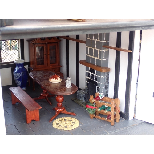 768 - A scratch built model of a timber framed black and white house, the roof made with areas of slating ... 