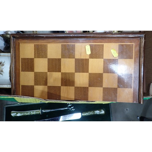 507 - A folding Chess Box containing wooden chess pieces, a pair of brass Candlesticks, a Carving Set in c... 