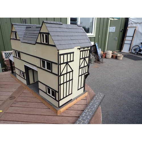 807 - A scratch built model of a timber framed black and white house, the roof made with areas of slating ... 