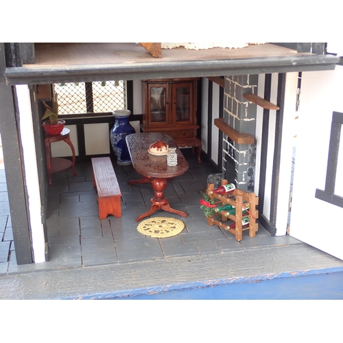 807 - A scratch built model of a timber framed black and white house, the roof made with areas of slating ... 