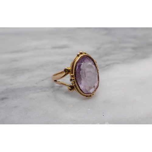 186 - An Amethyst Ring rubover-set oval-cut stone to split shank in 9ct gold, Chester 1916, ring size I