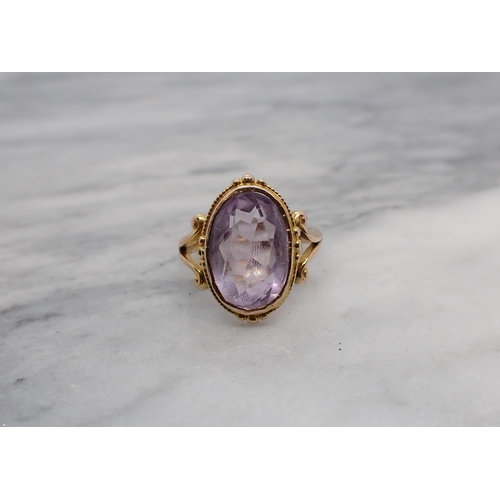 186 - An Amethyst Ring rubover-set oval-cut stone to split shank in 9ct gold, Chester 1916, ring size I