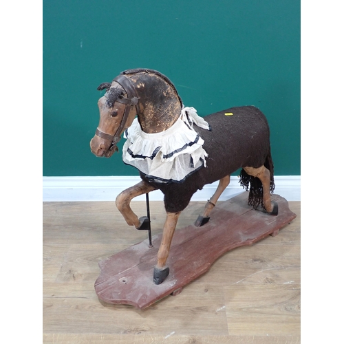 29 - An antique wool covered carved wooden and leather push along Horse on base 2ft 3in L x 2ft 2in H