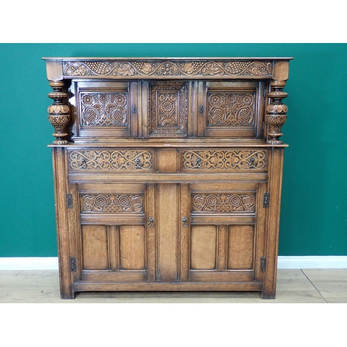 305 - An oak Court Cupboard in the 17th Century style with fruiting vine carved frieze fitted two drawers ... 