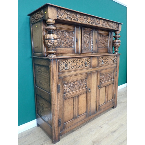 305 - An oak Court Cupboard in the 17th Century style with fruiting vine carved frieze fitted two drawers ... 