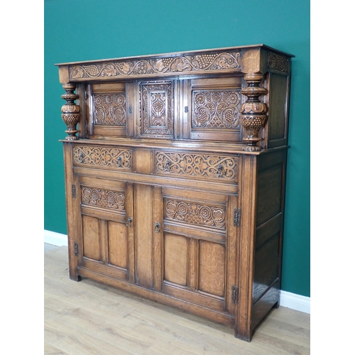 305 - An oak Court Cupboard in the 17th Century style with fruiting vine carved frieze fitted two drawers ... 