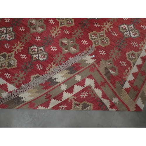 384 - An Oka Indian red ground Rug with bold geometric design 10ft 10in L x 8ft 5in W