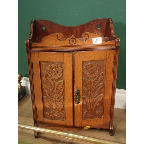 394 - A carved oak Smoking Cabinet, a copper Coal Scuttle, a brass Fire Curb and a pair of brass Taps