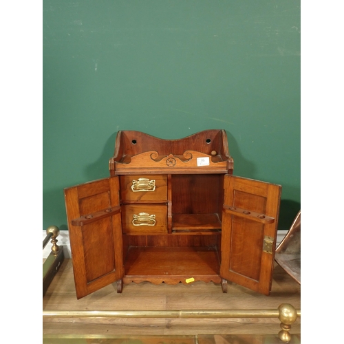 394 - A carved oak Smoking Cabinet, a copper Coal Scuttle, a brass Fire Curb and a pair of brass Taps