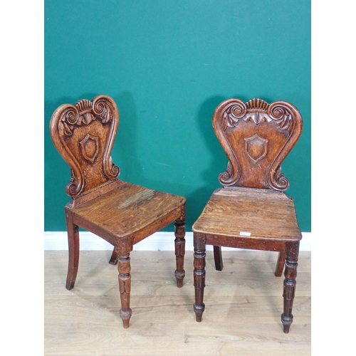 483 - A pair of Victorian oak Hall Chairs with carved scrolled backs