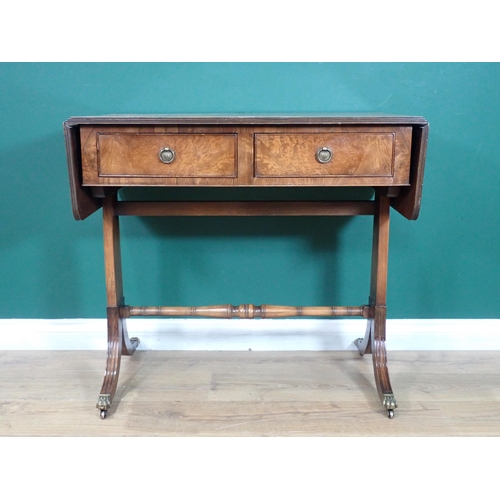 520 - A walnut veneered Sofa Table fitted two frieze drawers mounted upon cheval base with brass paw caste... 