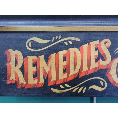 545 - A wooden hand 
painted Sign 'Remedies and Cures' 1ft 4in W x 7in H