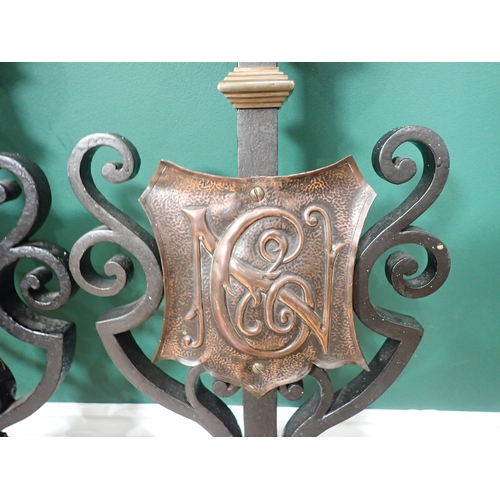 574 - A pair of wrought iron and brass Fire Dog fronts with armorial shield design