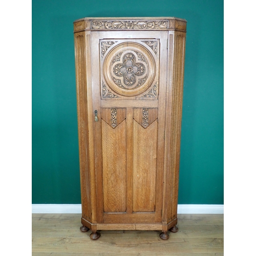 732 - An oak Hall Cupboard with canted corners and carved and panelled door mounted on turned supports 6ft... 