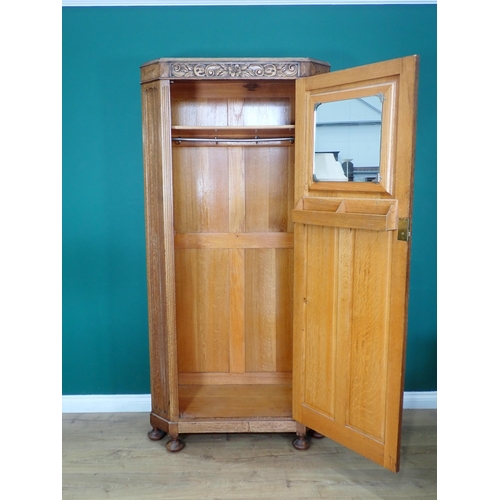 732 - An oak Hall Cupboard with canted corners and carved and panelled door mounted on turned supports 6ft... 