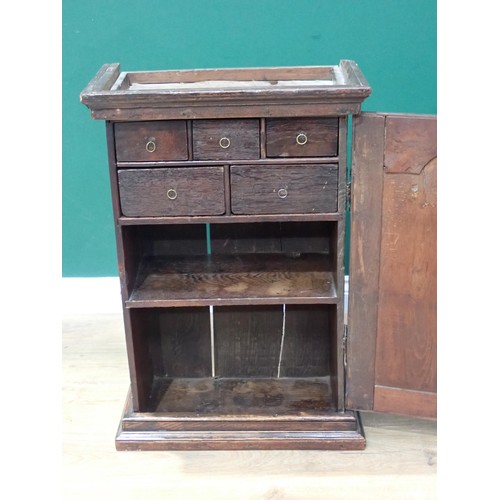 264 - An 18th Century oak Wall Cupboard with arched fielded panel door enclosing five drawers and shelves ... 