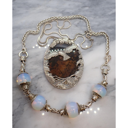 181 - A 'Silver Scenes' Necklace of oval agate within foliate silver frame with owl in flight on box-link ... 