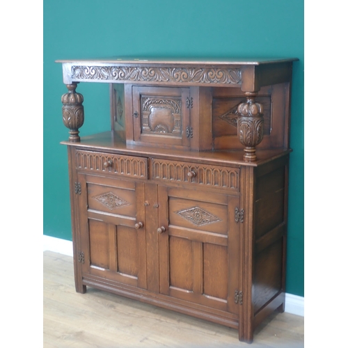 303 - A reproduction oak Court Cupboard in the 17th Century style fitted three carved panel doors and two ... 