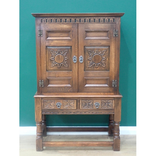 304 - An oak Cupboard on stand in the 17th Century style fitted pair of carved panel doors beneath nulled ... 